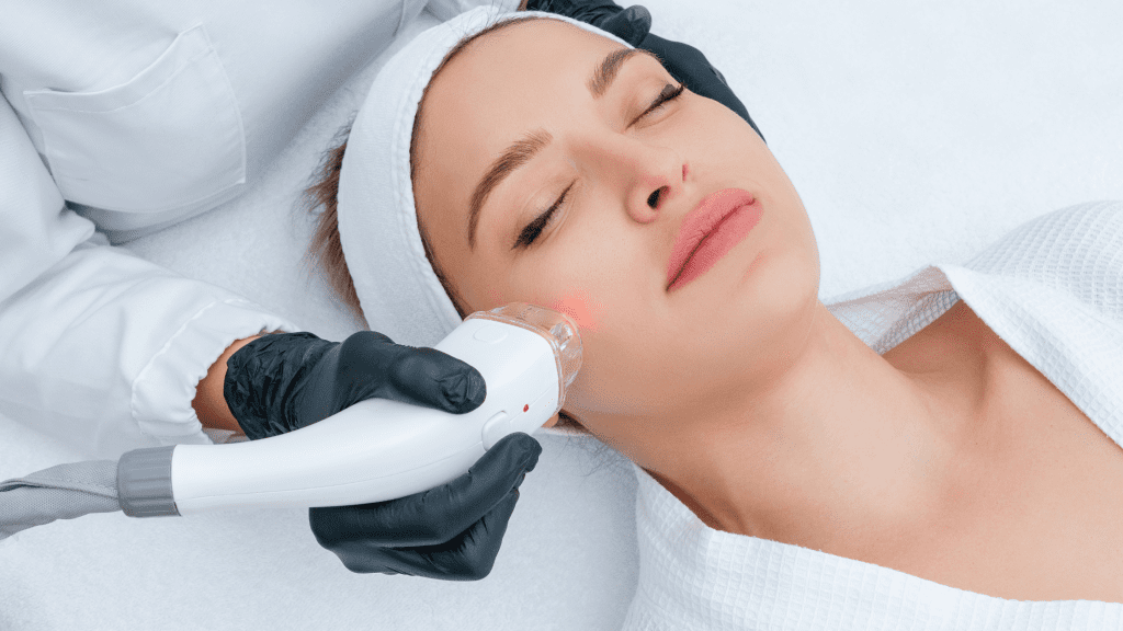 A person receiving a facial treatment with a handheld device on their cheek