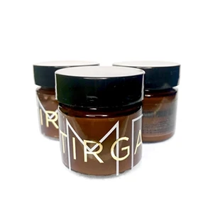 Three brown jars with black lids and white text on the front